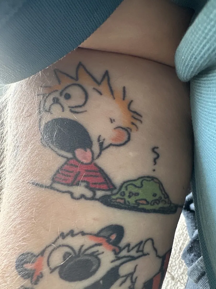Calvin and Hobbes style cartoon tattoos on a ribcage